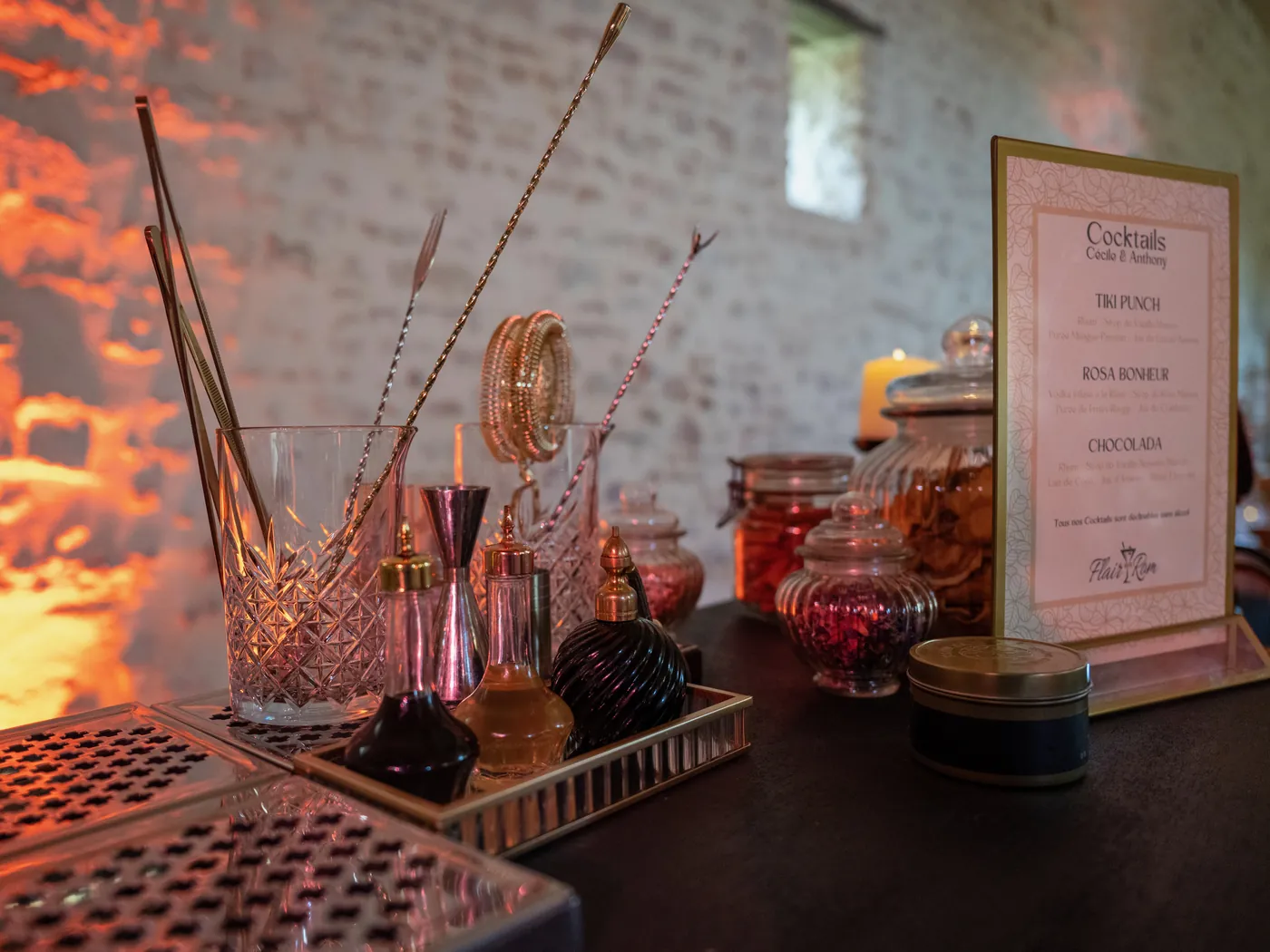 Bar à cocktails avec shakers, bocaux et carte de cocktails au nom des mariés
