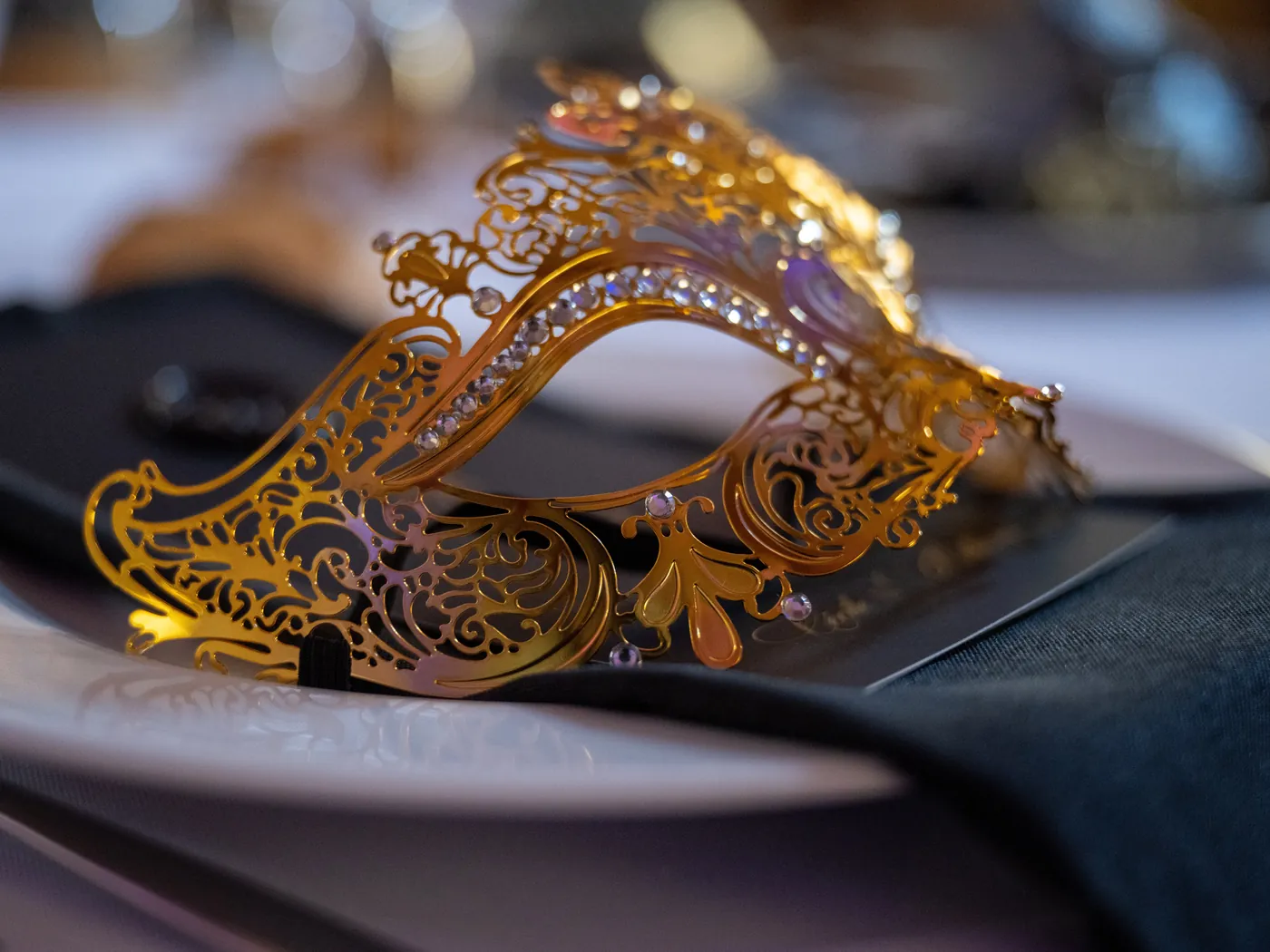 Masque doré en filigrane posé sur une assiette