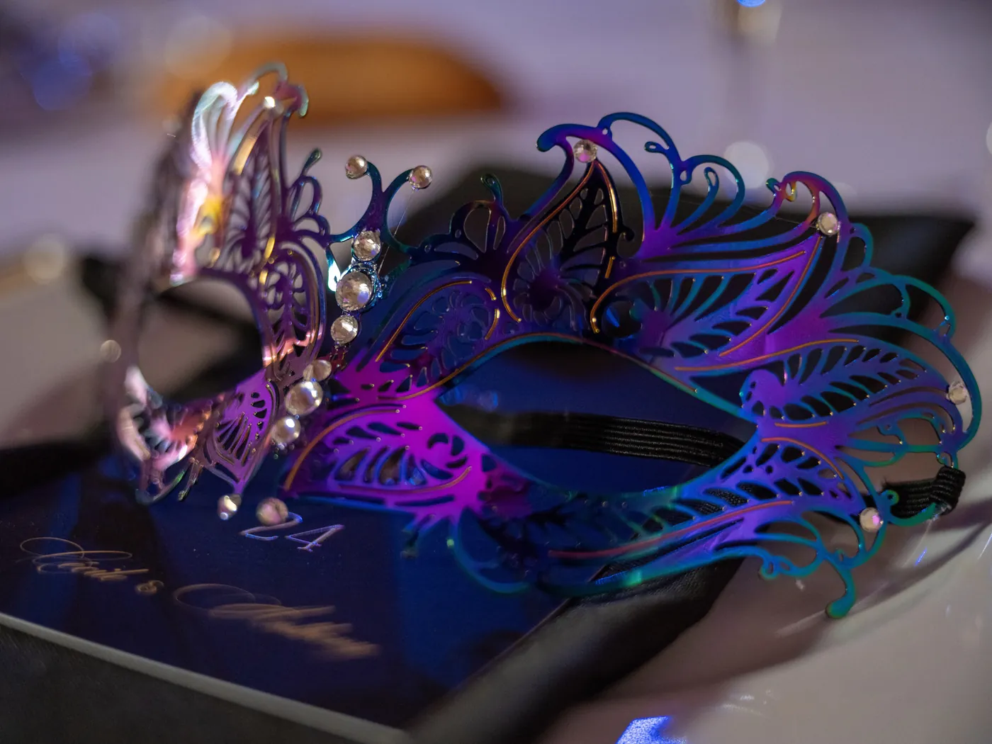 Masque irisé violet et bleu posé sur une assiette