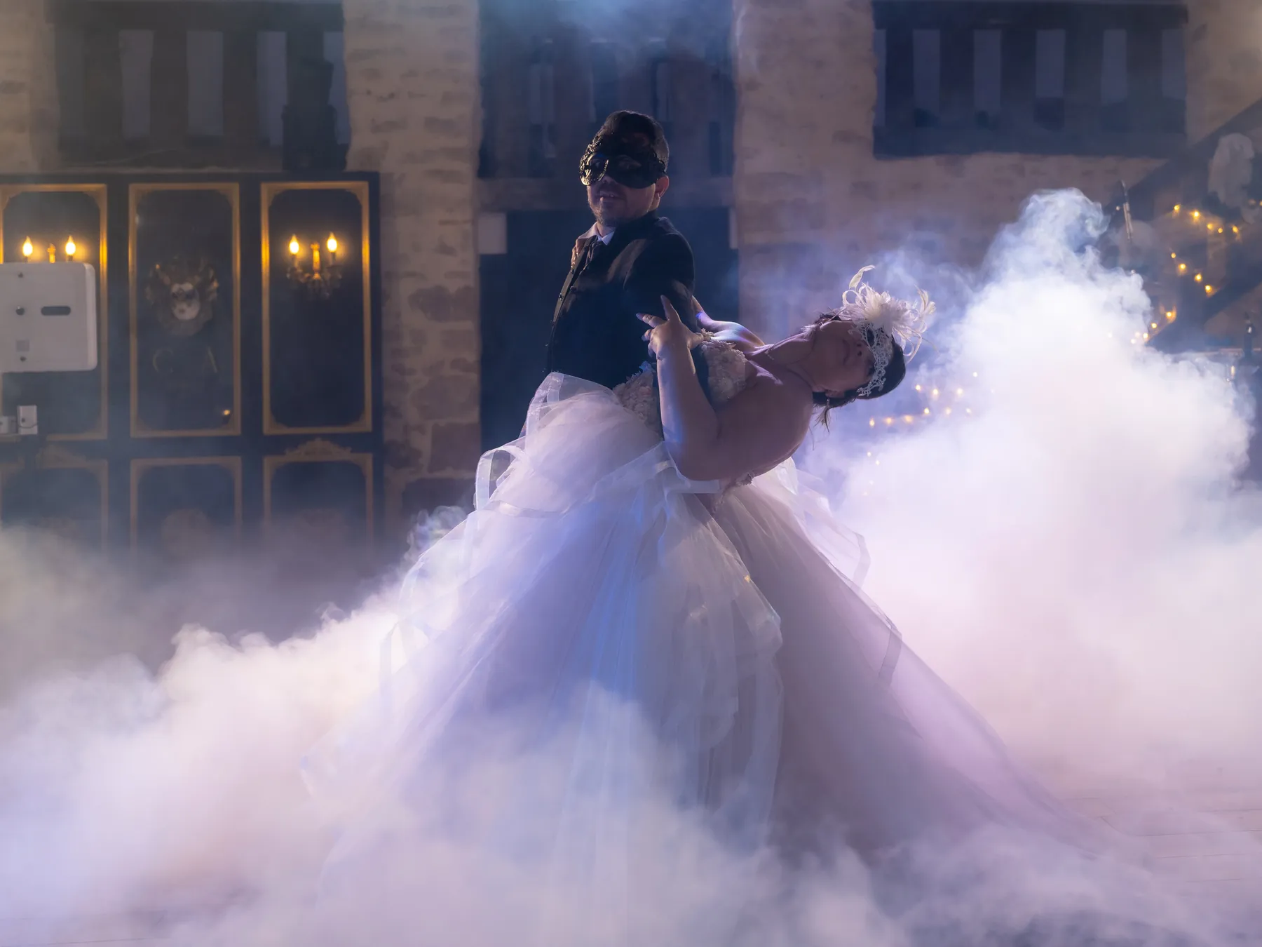 La mariée en robe de tulle dans la fumée pendant la première danse