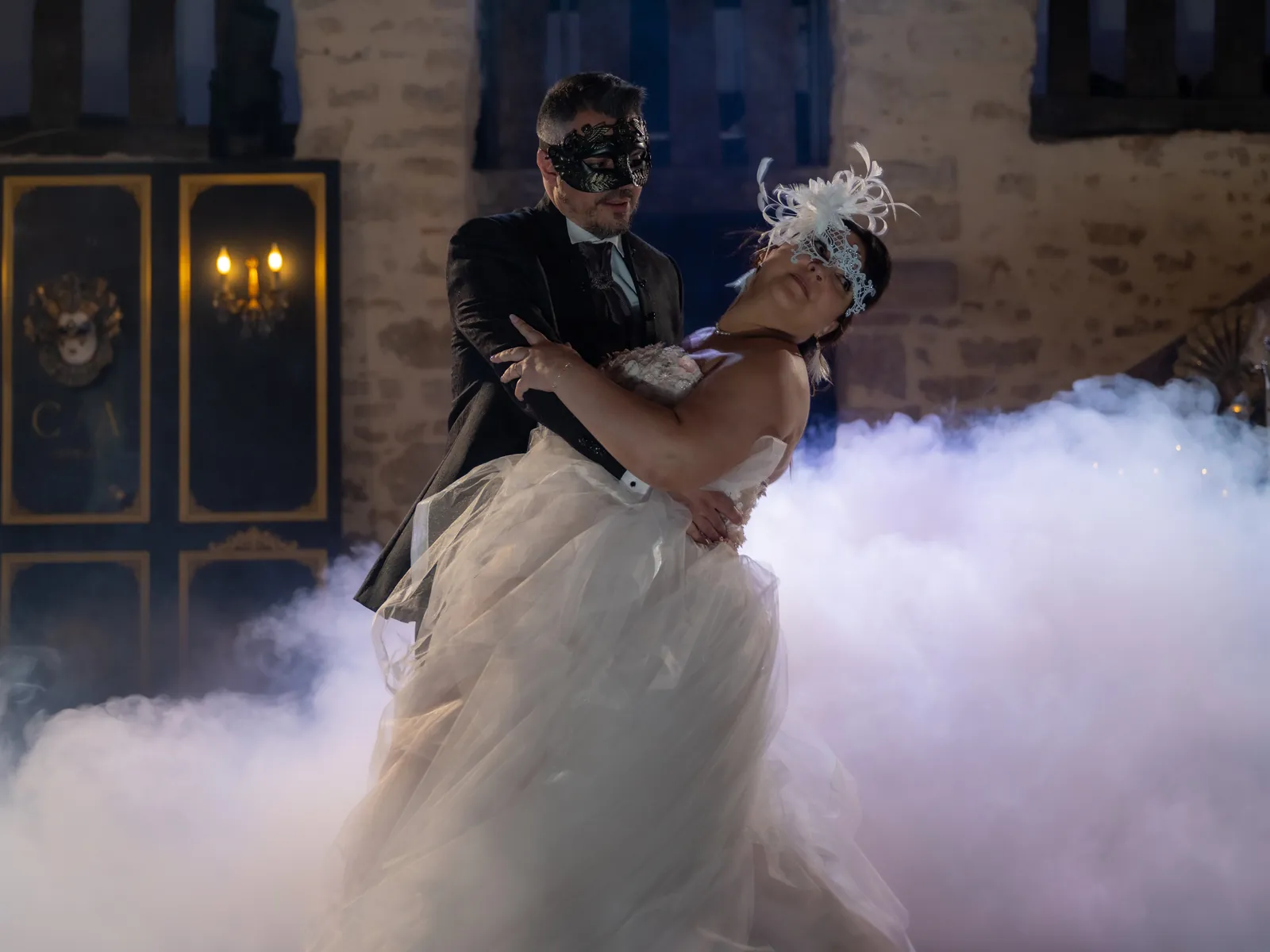 Le marié masqué penche la mariée dans la fumée