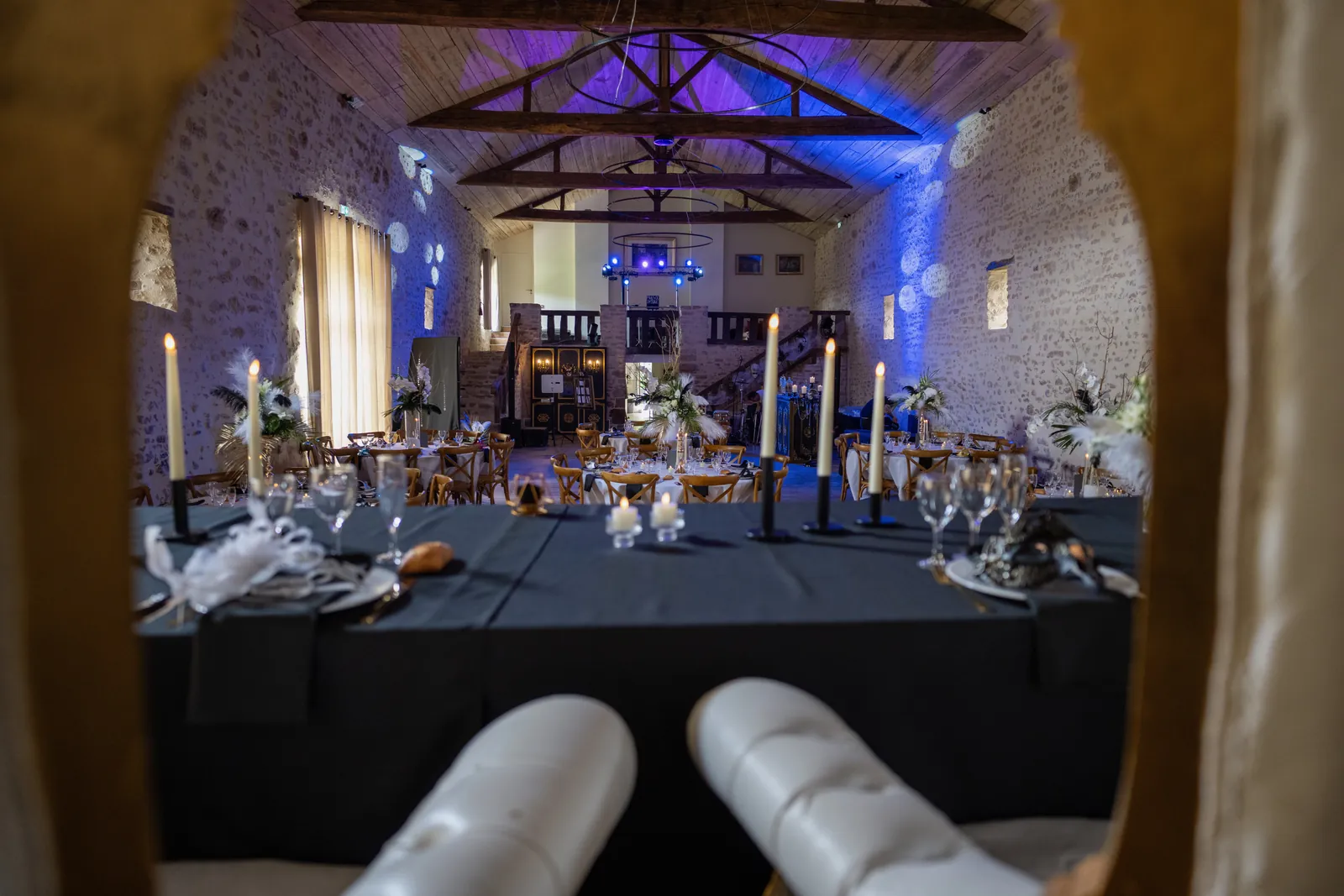 La table d'honneur vue à travers un cadre doré, avec bougies et plumes